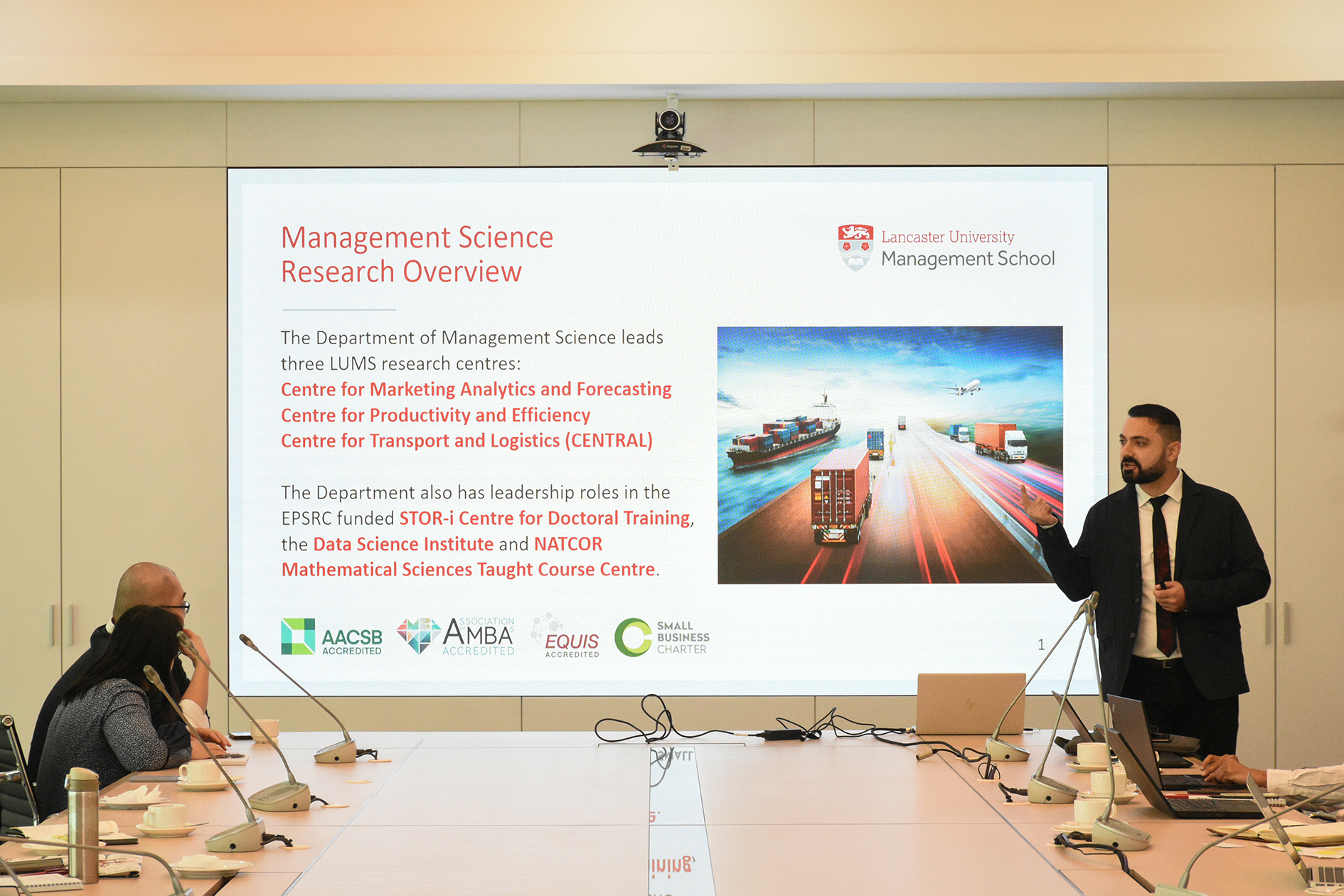 Dr Amjad Fayoumi gives a presentation at Sunway Business School, speaking in front of a large screen displaying a PowerPoint presentation about the Department of Management Science's research