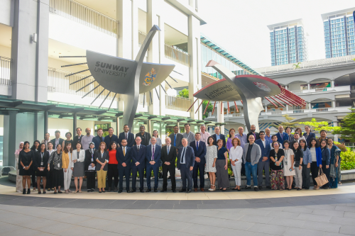 Conference attendees pose of for a group picture outside of Sunway University