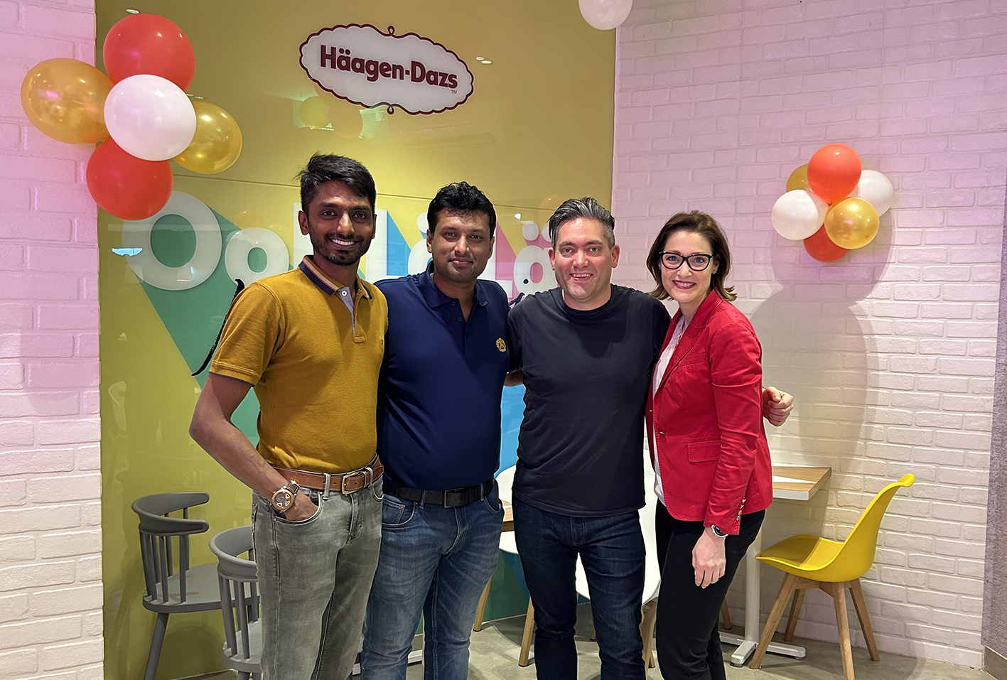 Rohit Murthy and Mayank Podar stand with Pete Cornwall and Dr Robyn Remke, from Lancaster University Management School, in their Häagen-Dazs store