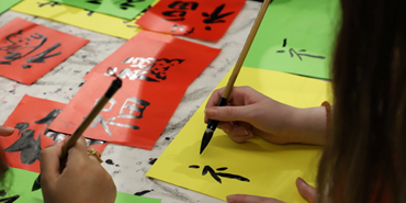 A photo of people practicing Chinese calligraphy