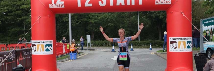 Woman passing the finish line at Triathlon event