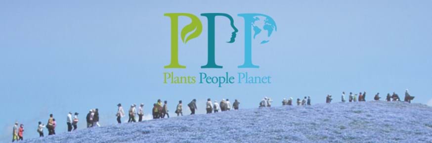 Plants, People, Planet logo over people walking through a meadow of blue flowers