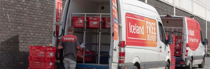 Image of a delivery driver unloading supermarket shopping.
