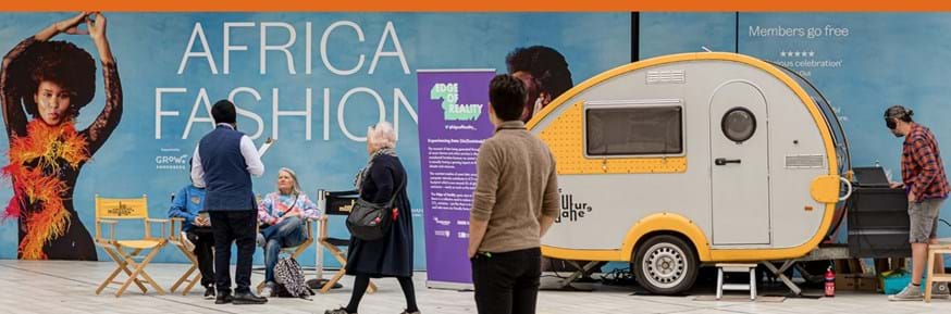 An image of a yellow and gray caravan at the Edge of Reality exhibition.