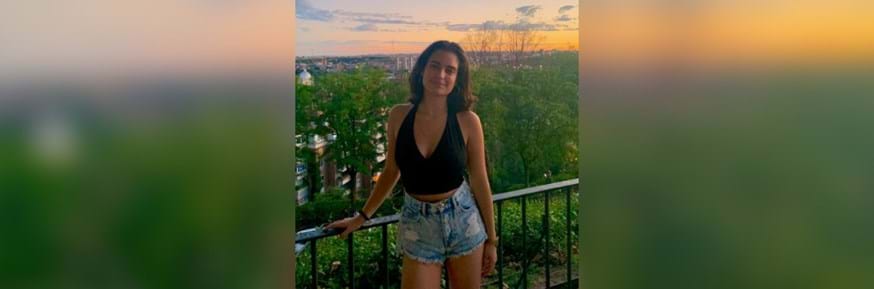 Carmen stood at a city view point with a sunset