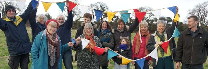 People from Bridport Cohousing enjoying an event with colourful bunting