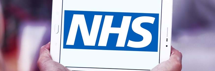 A digital tablet displaying an NHS logo