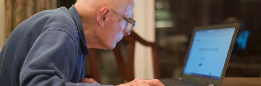 An elderly man using a laptop computer