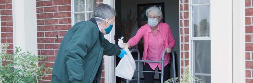 A volunteer delivering goods to a vulnerable woman during the pandemic