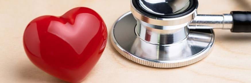 A shiny red plastic heart and a stethoscope