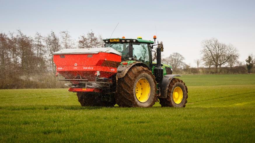 A tractor spreading fertilizer