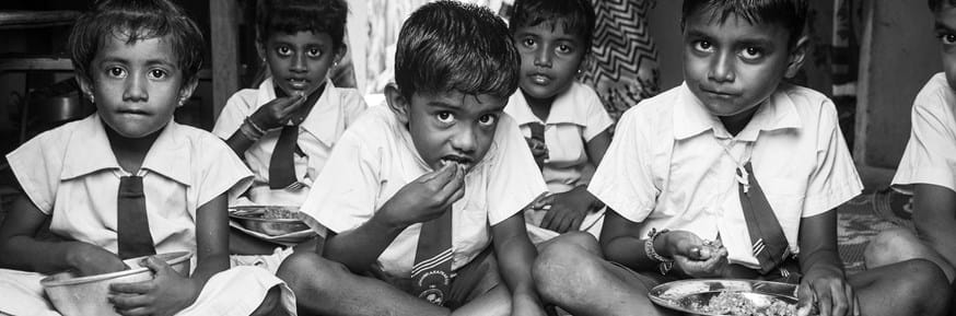 Indian children in uniforms eating together