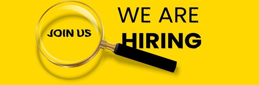 A bright yellow background, with black text. The words JOIN US are caught in the lens of a magnifying glass, accompanied by WE ARE HIRING.