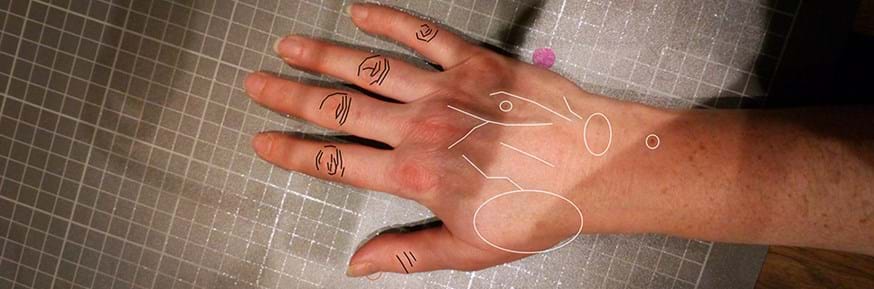 A photograph of a person's hand, with identifying features of the hand marked with digital illustrations