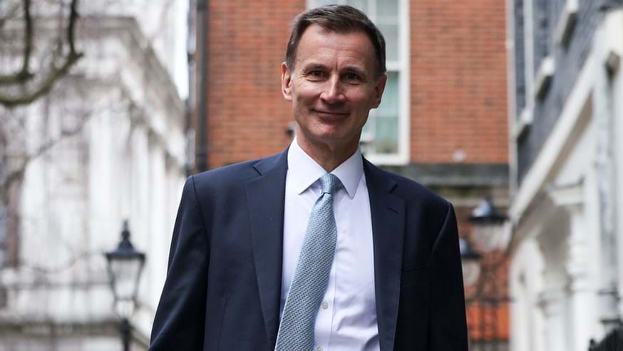Chancellor Jeremy Hunt walking down Downing Street with his red briefcase.