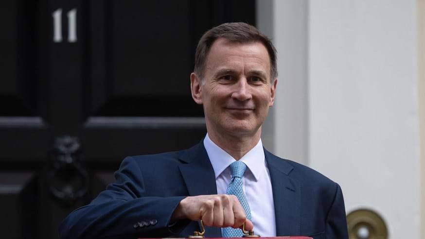 Chancellor Jeremy Hunt holding the Chancellor of the Exchequer's red briefcase.