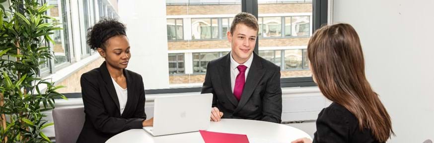 Two students at Lancaster University Law Clinic talking to a client