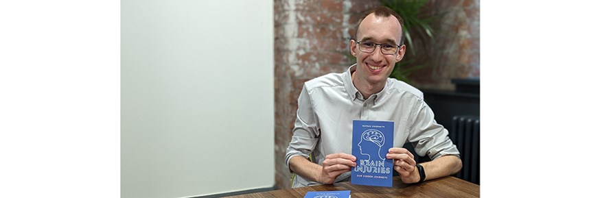 Nathan Shoesmith smiling, holding his new book