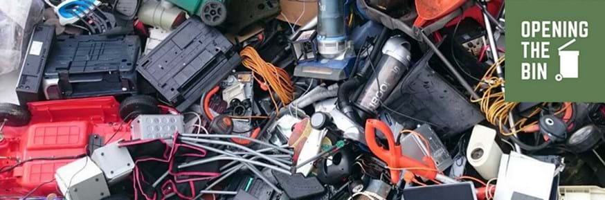 A jumble of electronic waste, including wires and vaccuum cleaners, at a civic amenity site