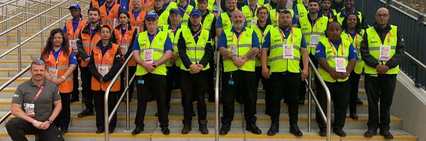 Peter Harrison (front left) kneels in front of his FGH Security team at the 2022 Commonwealth Games in Birmingham.
