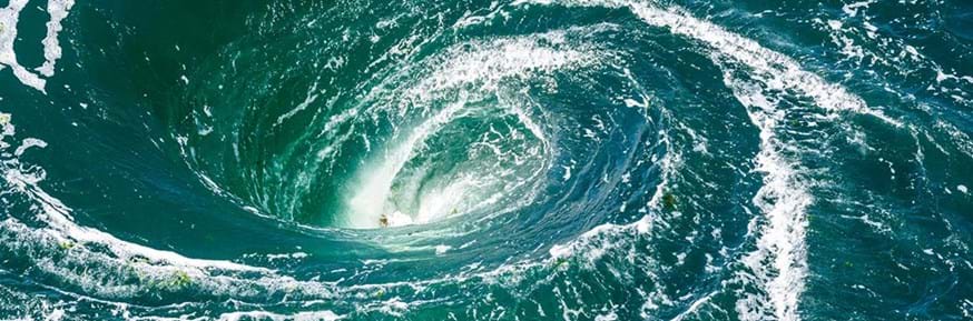 A powerful whirlpool is generated at the surface of the green waters of the river Rance by the action of a turbine of the tidal power station near Saint-Malo in Brittany, France