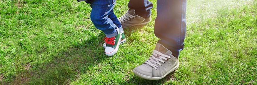 Child and Adult legs and feet together on the grass