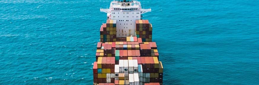 A ship with containers on it of various colours.