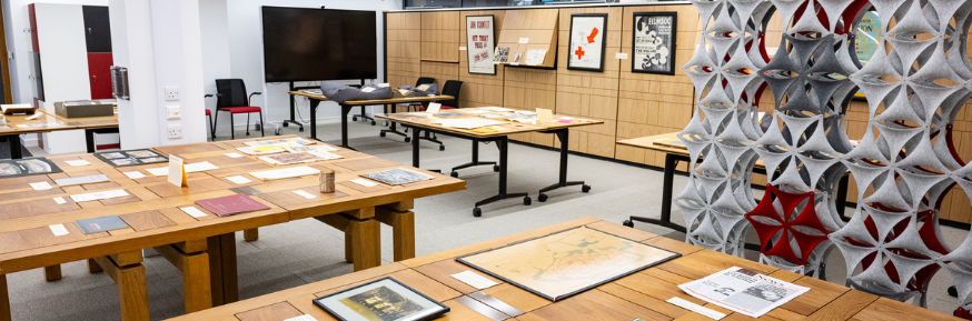 An image of the archive research centre. There are items from the collection displayed on wooden tables.