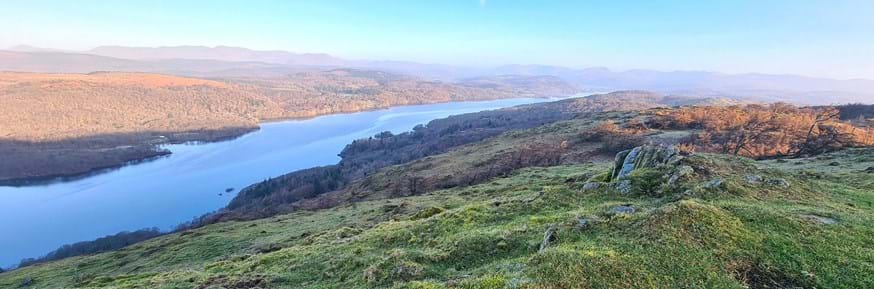 An elevated view of Windermere on a sunny day with a misty horizon
